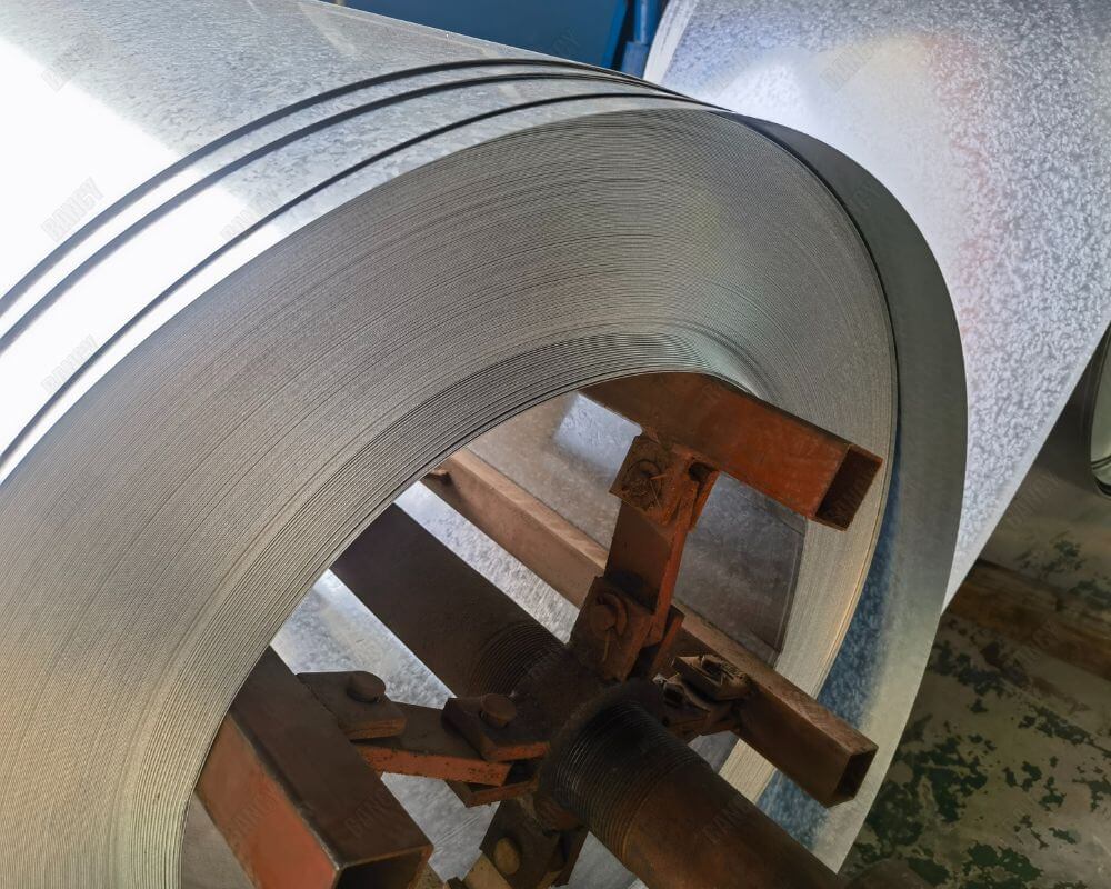 Coiled metal sheets used in production, showcasing material preparation