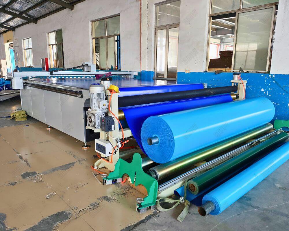 Multi-roll fabric cutting machine displaying different colored materials for production