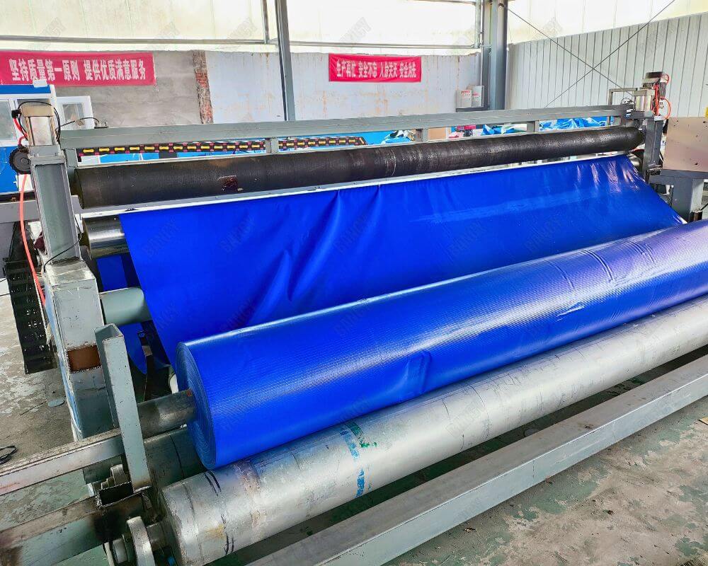 Fabric cutting machine with blue rolls preparing materials for production