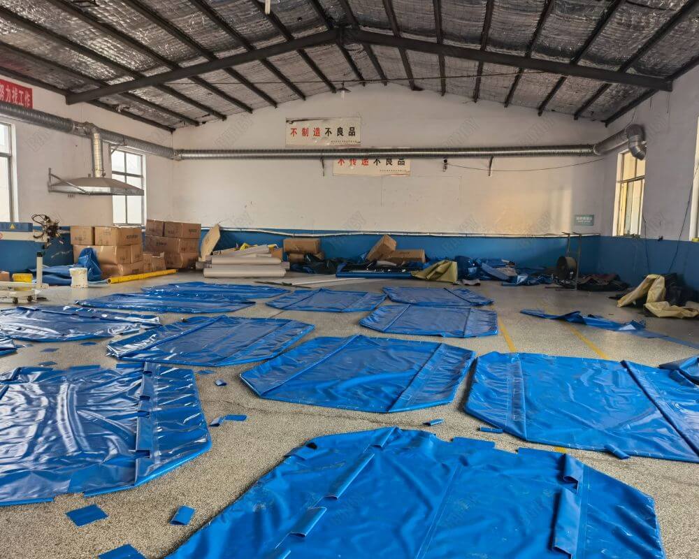 Prepped blue materials for aquaculture tanks spread out in a workshop