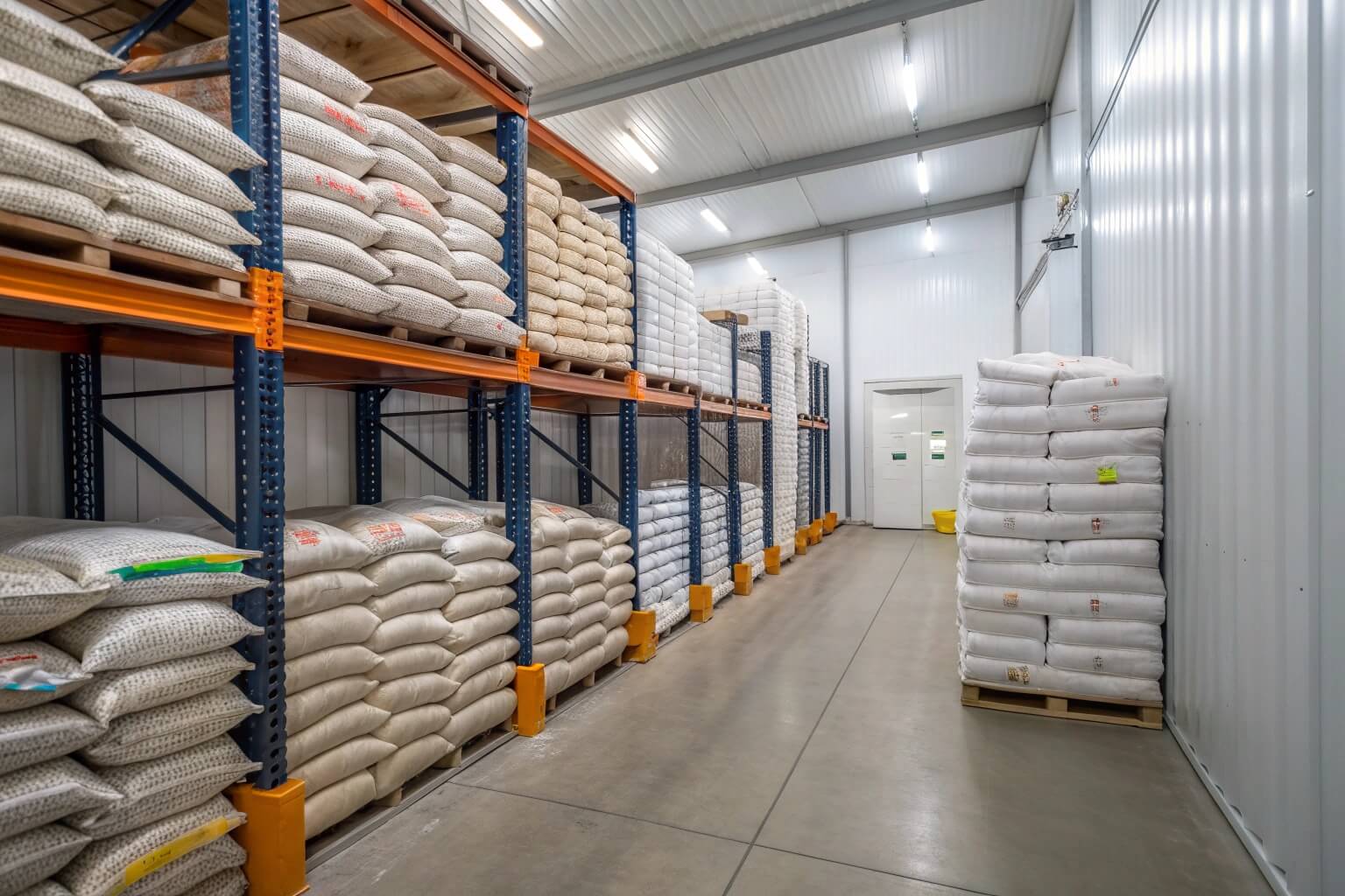 Bags of catfish feed stacked in a storage room