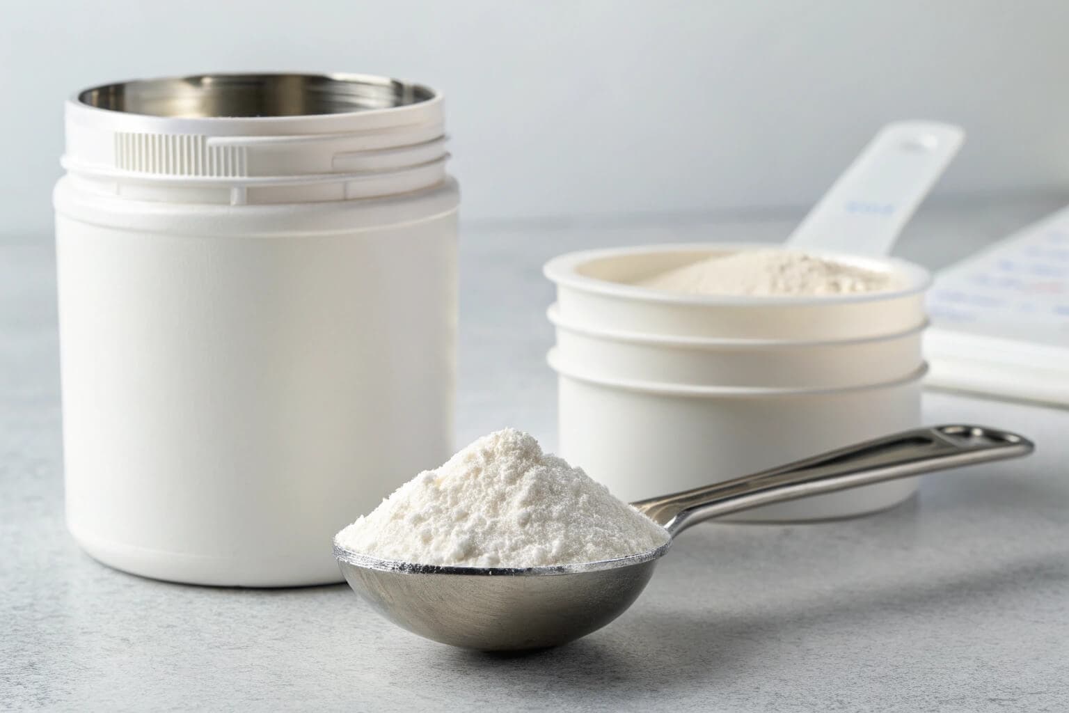 A container of biofloc probiotics next to a measuring spoon