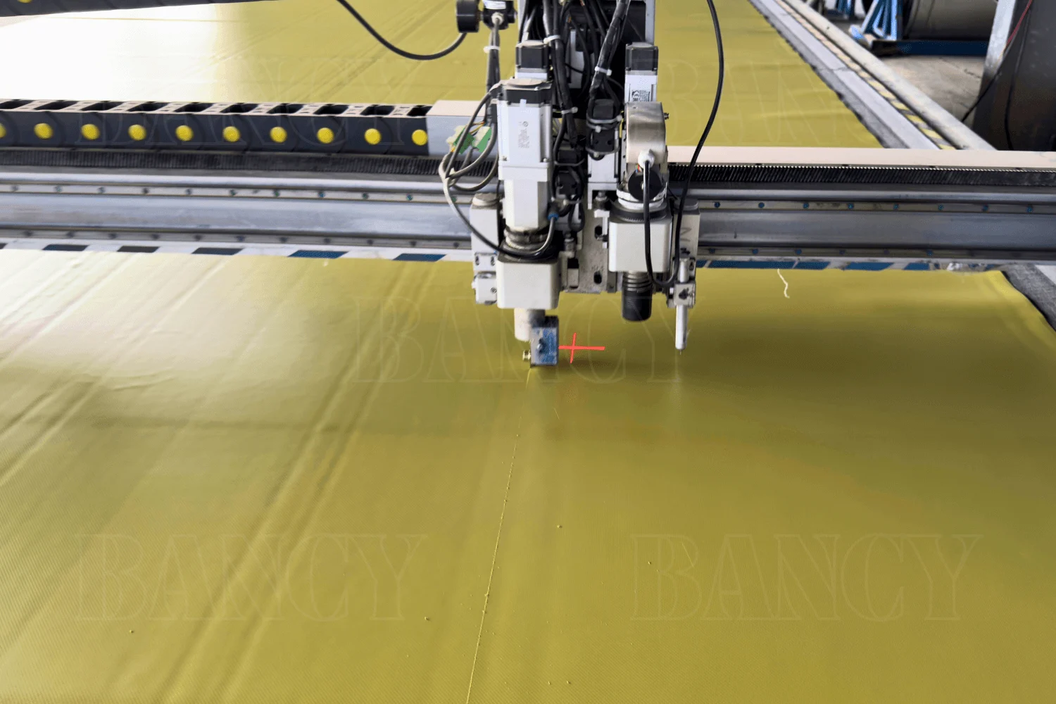 High-speed automated computer-controlled cutting plotter slicing TPU/PVC material with precision.