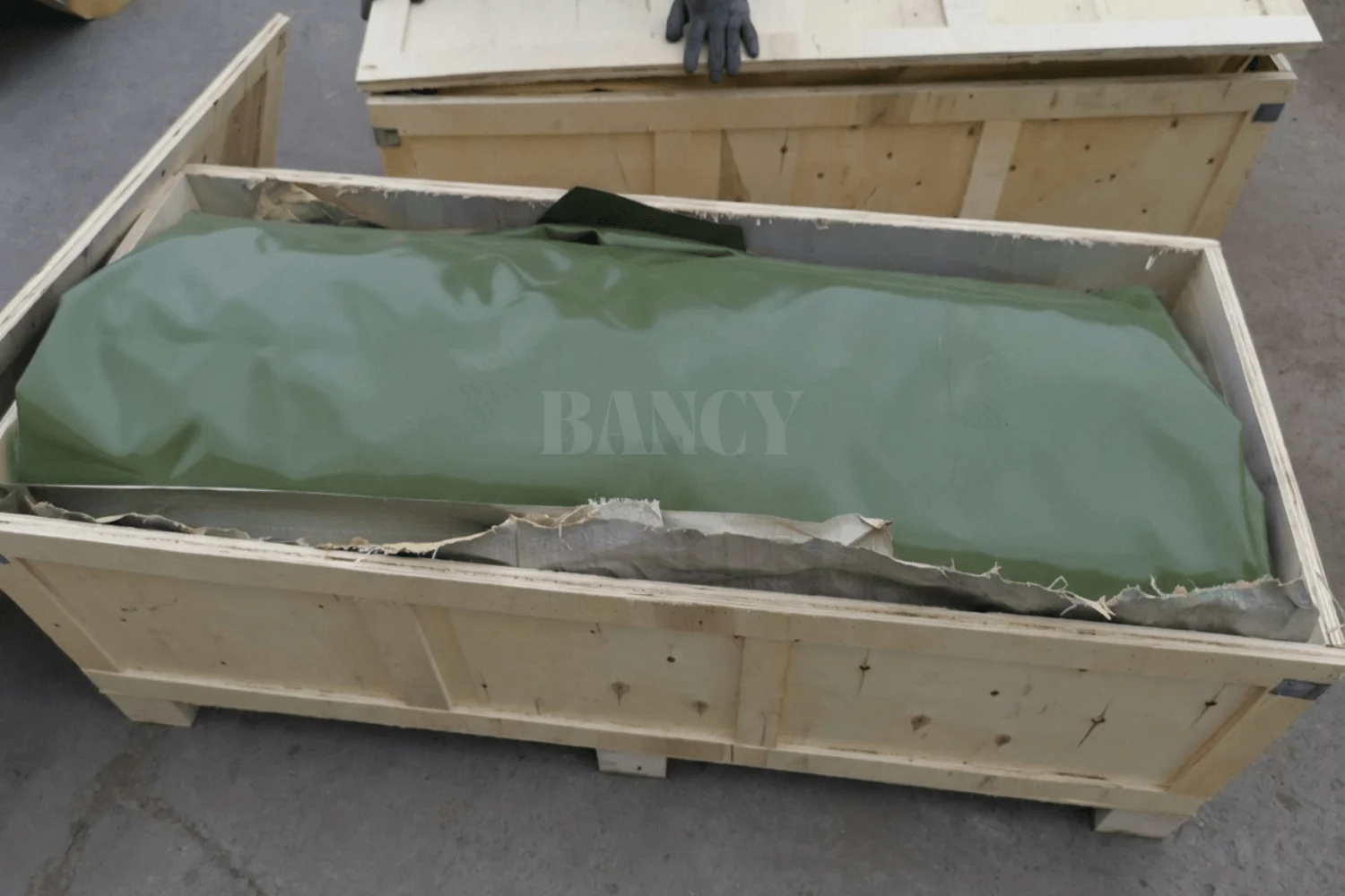 Large agricultural water tank folded compactly inside a wooden shipping crate for export.