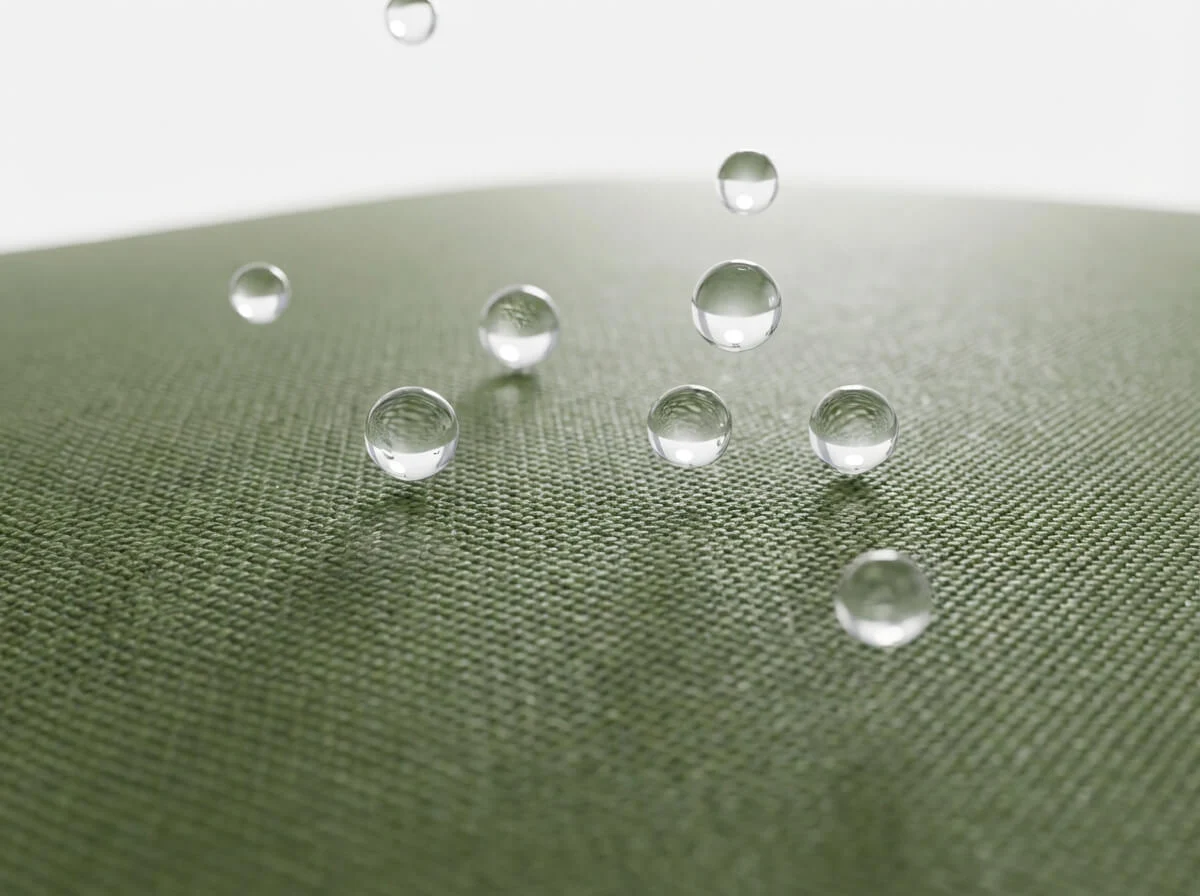 Macro 3D render of water droplets beading on green PVC fabric surface showing hydrophobic properties.
