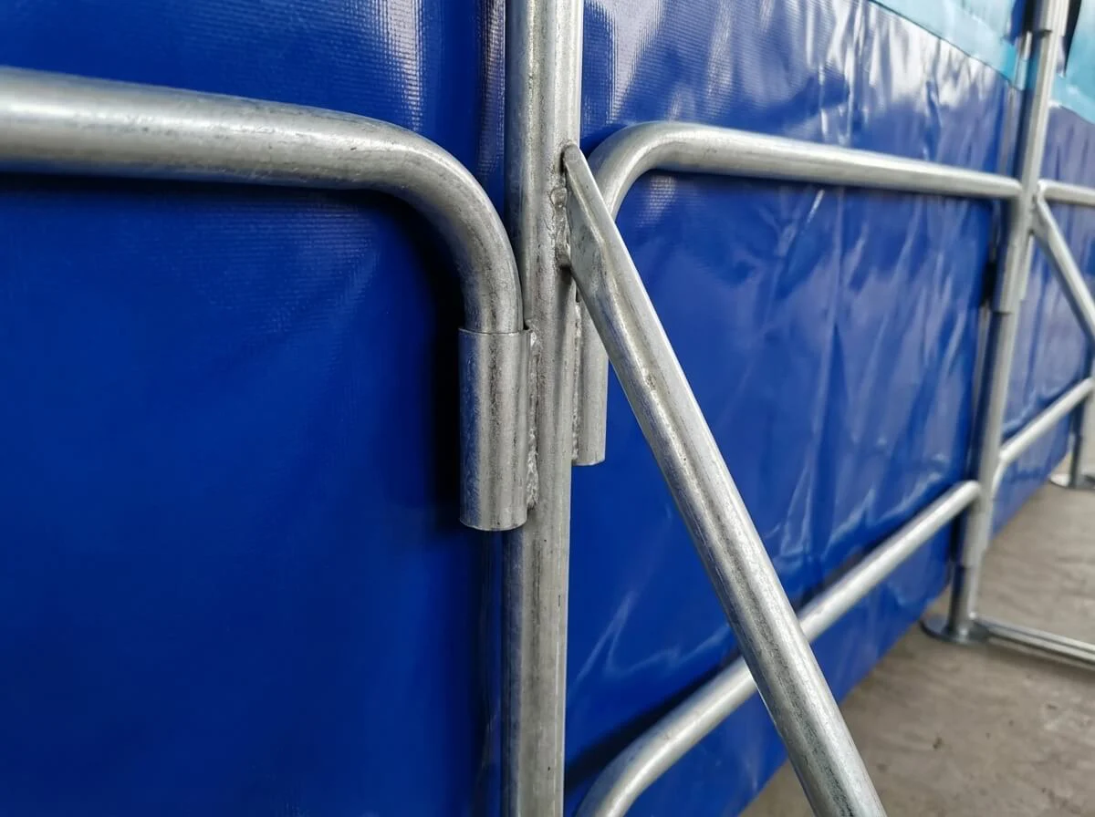 Close-up of the triangular galvanized steel buttress supporting the blue fish tank wall.