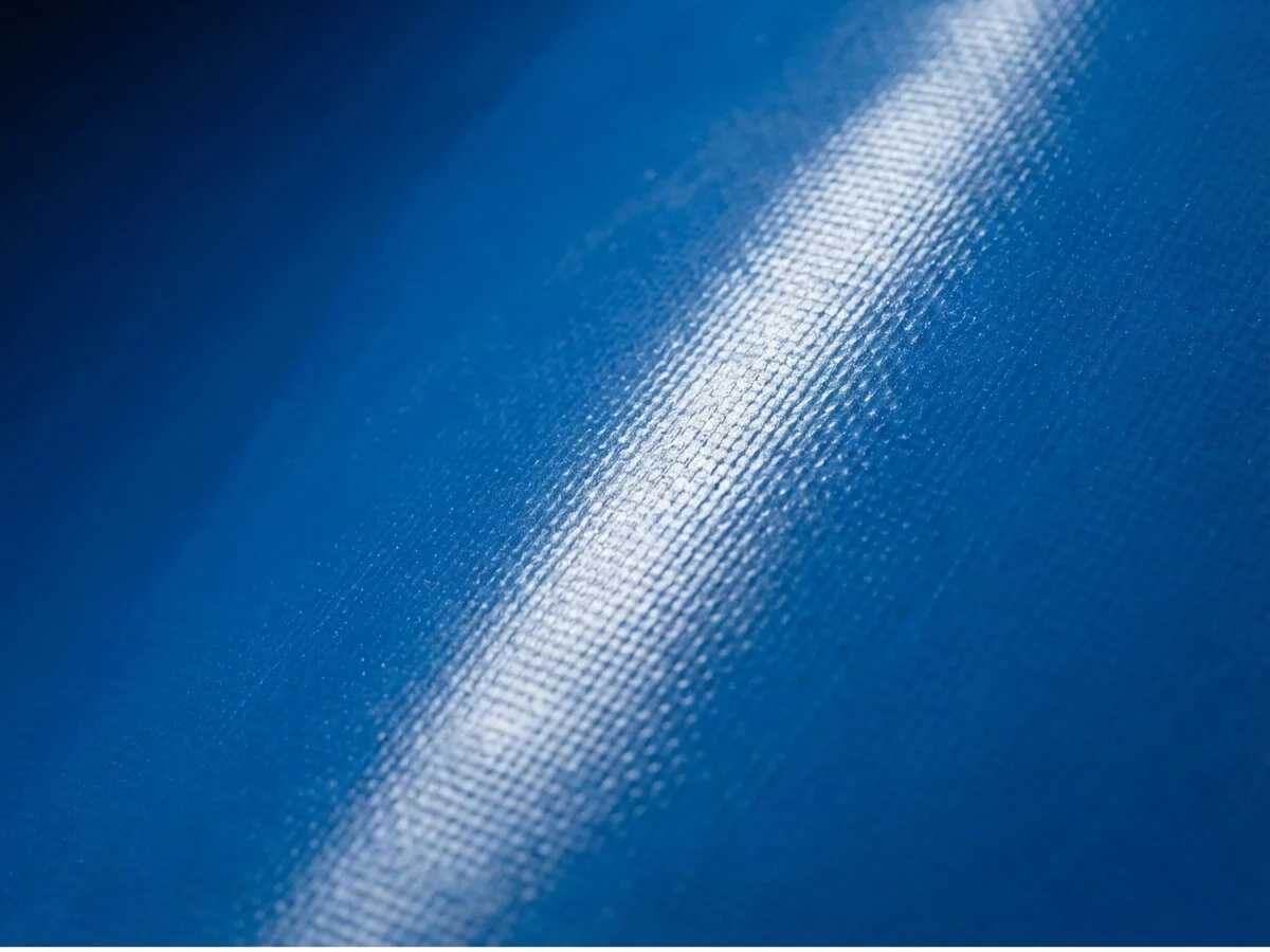Macro shot of smooth blue PVC liner texture designed to prevent bacteria and protect fish skin.