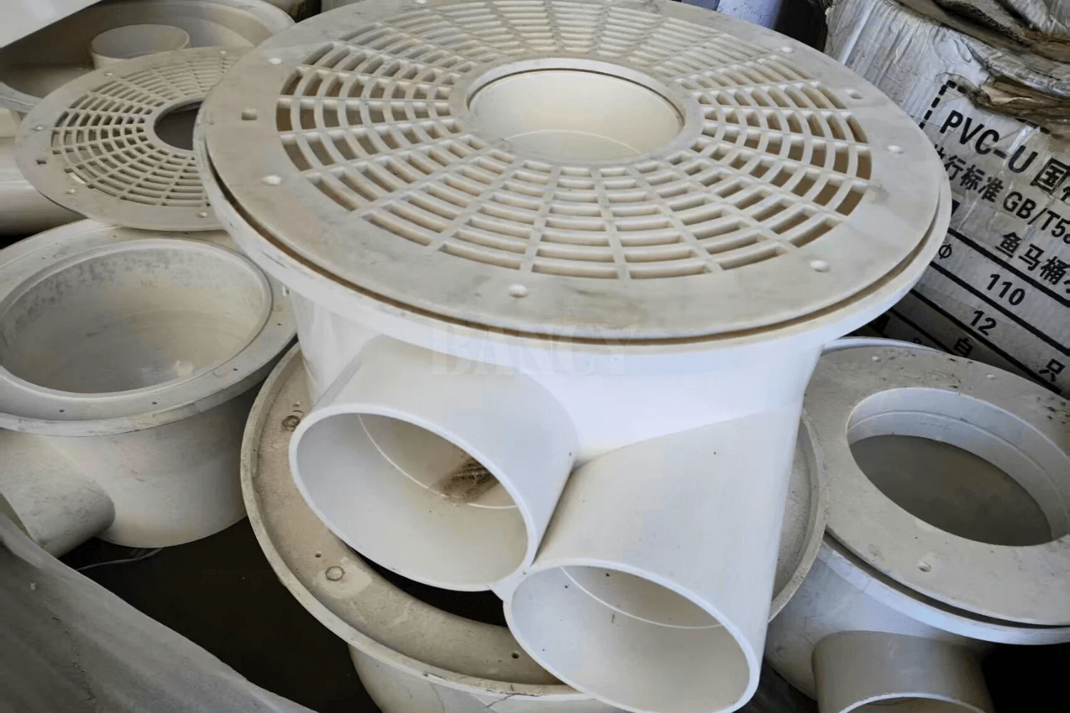 White UPVC bottom drain and piping fittings for RAS tank integration.