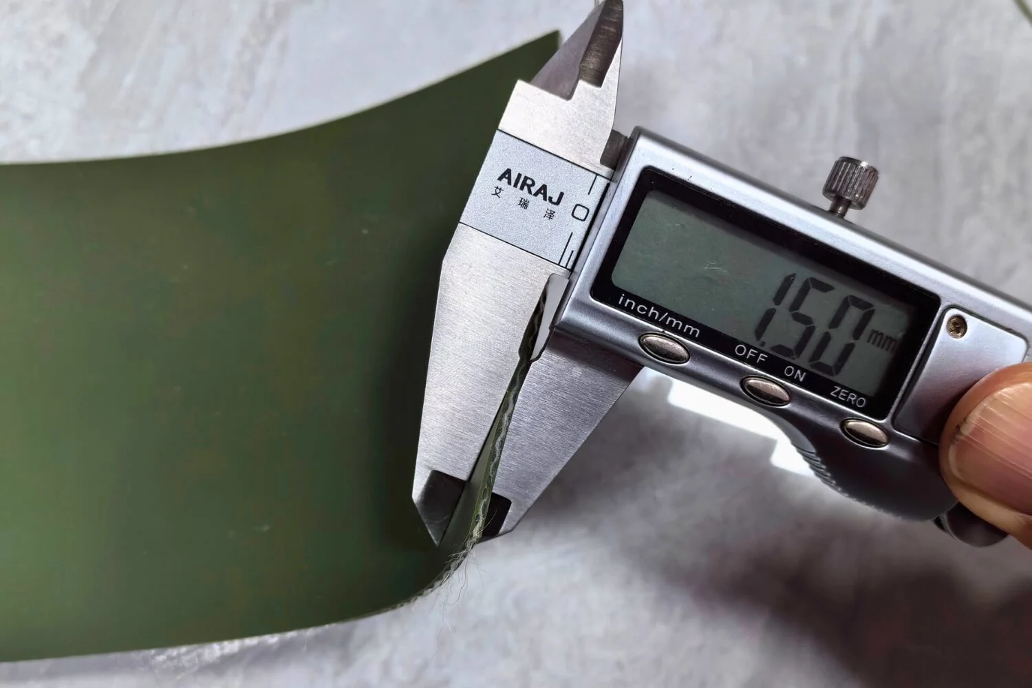 Quality inspector measuring PVC fabric thickness with digital caliper