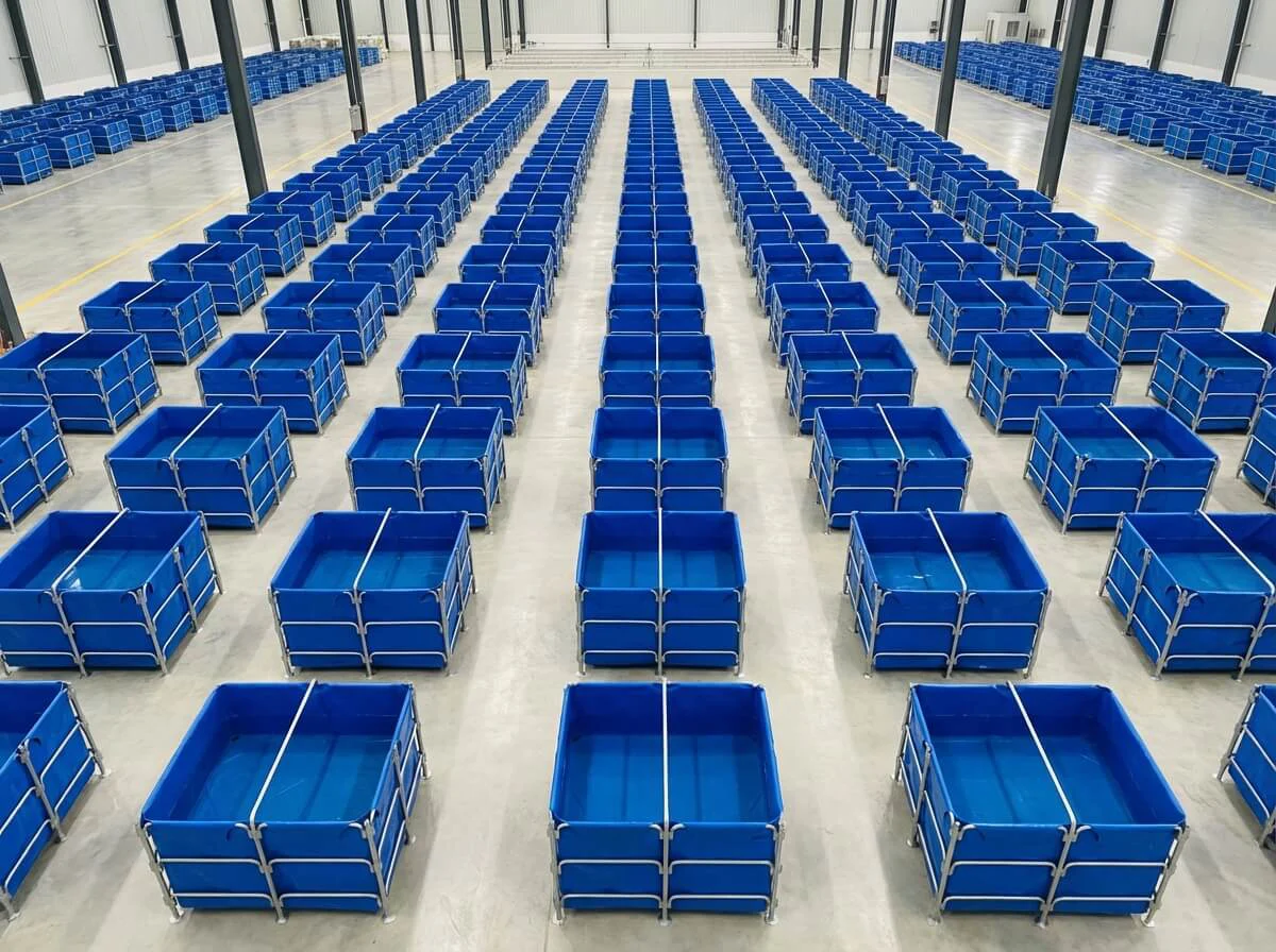 Aerial view of square fish nursery tanks arranged in a tight grid to maximize factory floor space.