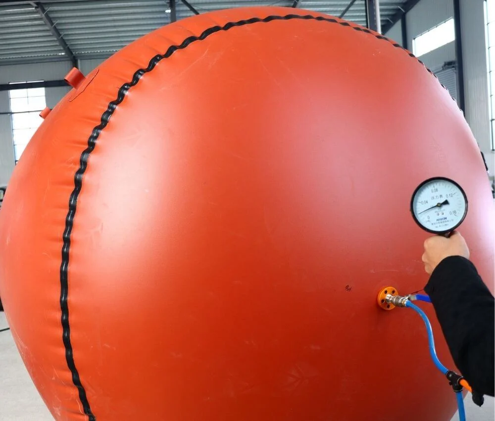 Technician using a pressure gauge to test the gas-tightness of a low-pressure inflatable biogas balloon in the Bancy factory.