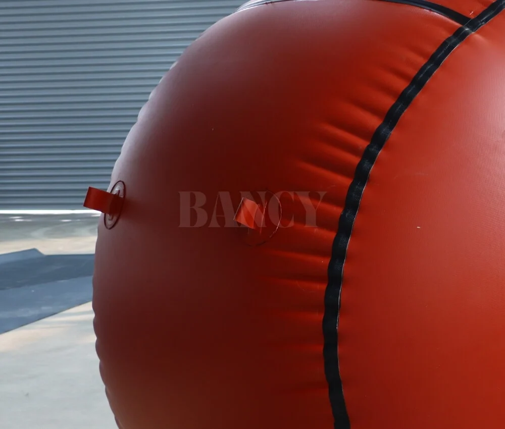 red mud biogas balloon tie down loops Close up of reinforced tie-down anchor loops on a flexible red mud biogas holder.